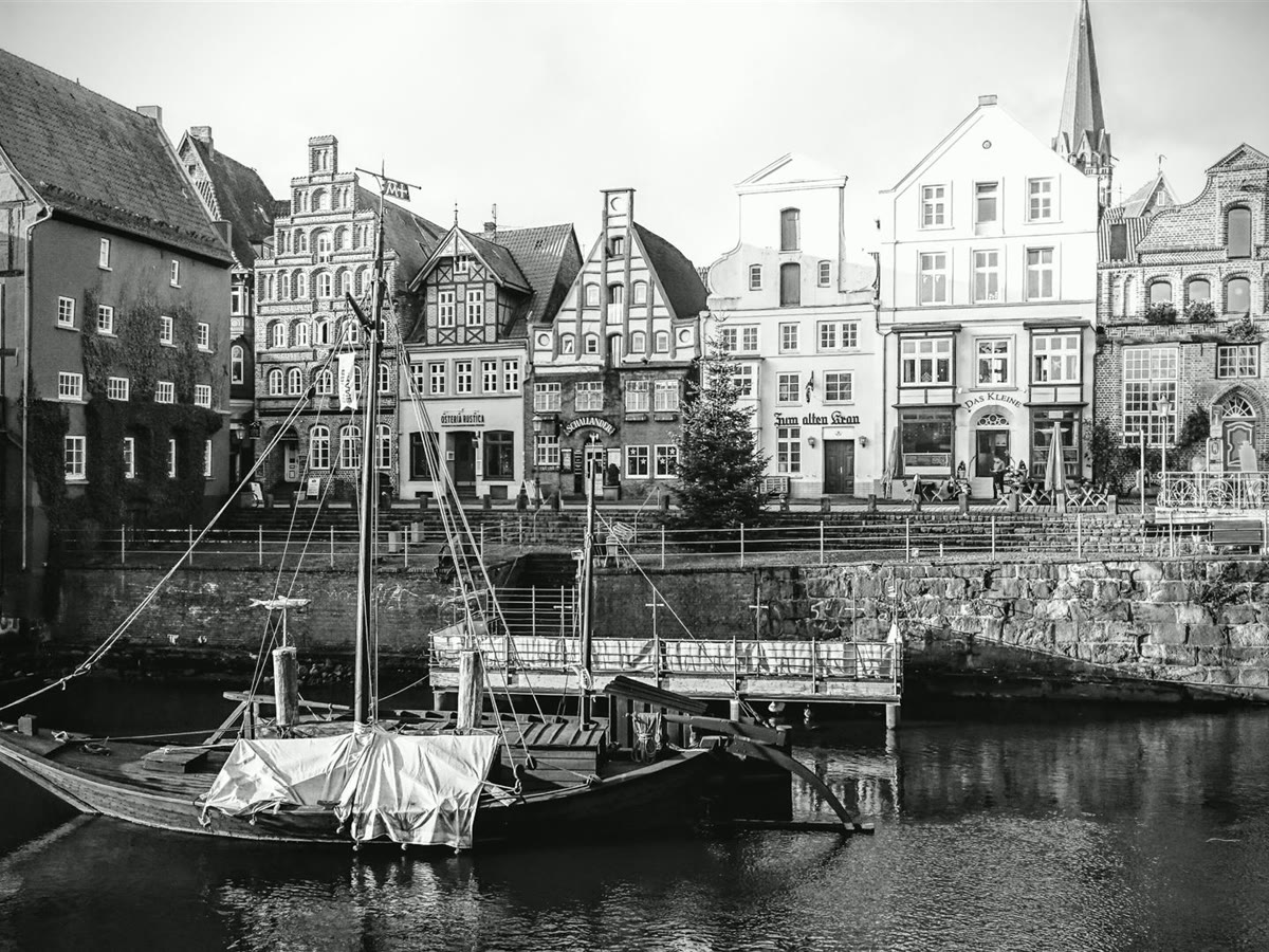 Der Stintmarkt in Lüneburg mit historischem Kahn und den alten Giebelhäusern am Wasser